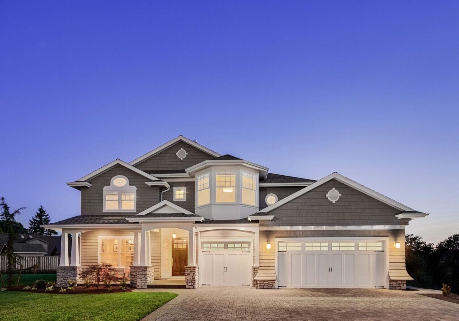 A large house with two garage doors and a driveway.