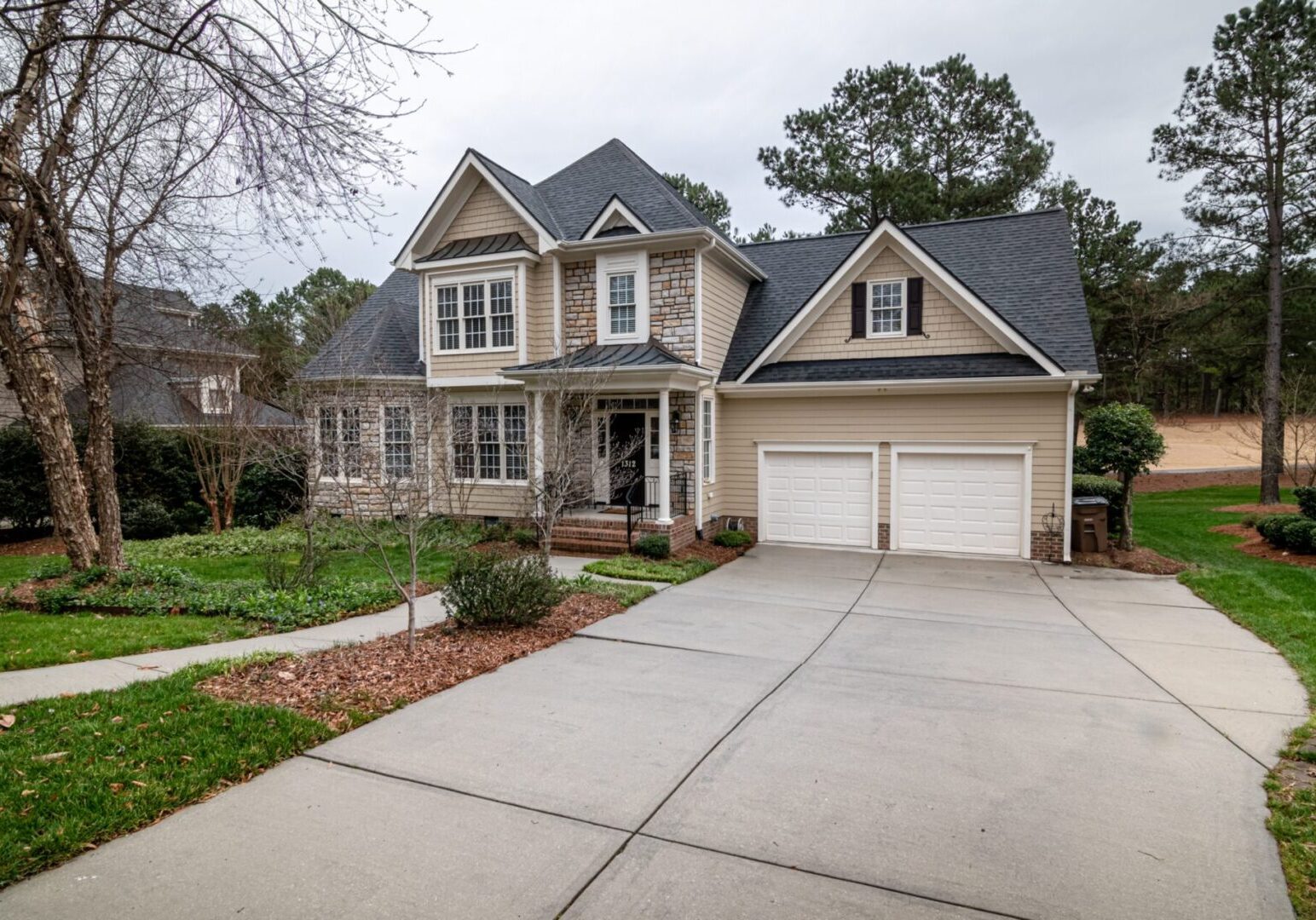 A large house with two garage doors and a driveway.